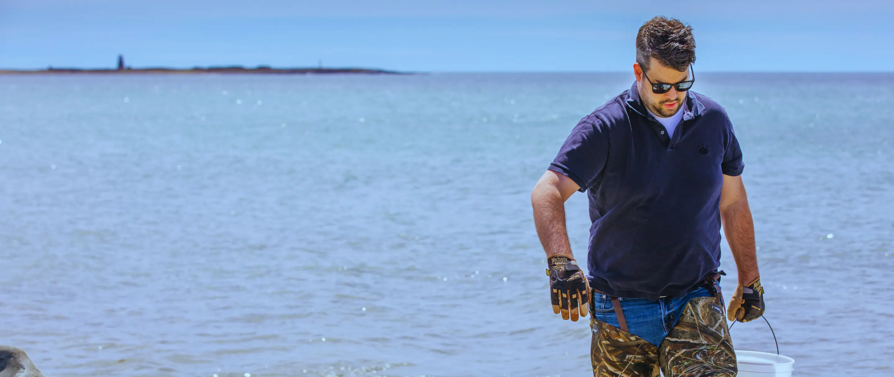 A Tidal Salt maker gathering seawater on a rocky Nova Scotia shore